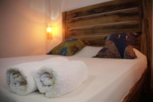 une paire de serviettes assises sur un lit dans l'établissement Siki Hotel, à Saint-Louis