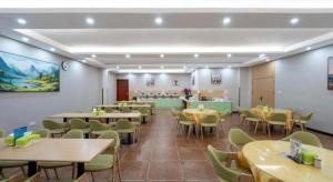 un ristorante con tavoli e sedie in una stanza di GreenTree Inn Linxi International Convention Center Express Hotel a Wangjiaqiao