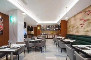 a restaurant with tables and chairs in a room at Jinjiang Inn Nanjing Changjiang Bridge North Metro Station in Taishan
