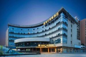 a large building with a sign on top of it at Jinjiang Inn Nanjing Changjiang Bridge North Metro Station in Taishan