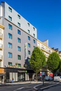 un gran edificio en una calle de la ciudad con coches aparcados en Campanile Rennes Centre - Gare en Rennes