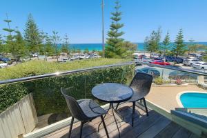 a balcony with a table and chairs and a pool at Sunset Spa Escape - Ocean Views in Perth