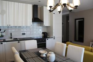 a kitchen with a table with chairs and a dining room at Luxury Apartment in Druskininkai