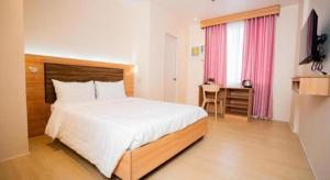 a bedroom with a bed and a desk in a room at JVJ HOTEL in Batangas City