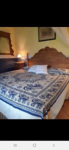 a bedroom with a bed with a blue and white comforter at Finca Sencilla in Mijas +13 photos