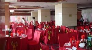 una stanza piena di tavoli e sedie rosse con persone dentro di Qingdao Donghai Hotel a Qingdao