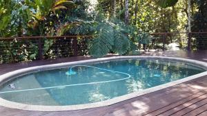 a hot tub on a deck with a wooden deck at Kuranda Ngorongoro Lodge in Kuranda