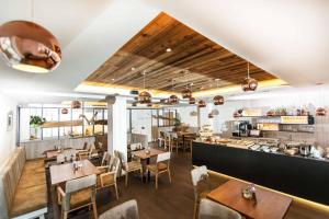 un ristorante con tavoli, sedie e un bancone di Apartmenthotel 's Mitterndorf a Traunkirchen
