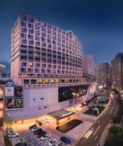 a large building with a parking lot in front of it at Nanjing Rsun Hotel in Taishan