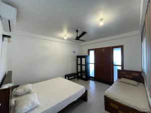 ゴールにあるMilano Apartment & Roomsのベッド2台と天井ファン付きの寝室