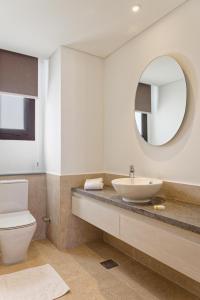 a bathroom with a sink and a toilet and a mirror at VESTA - El Gouna Residence in Hurghada