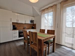 a kitchen with a wooden dining table and chairs at Ferienwohnung in Zingst Müggenburg, hochwertig und ruhig urlauben in Müggenburg