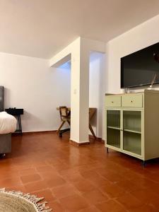 ein Wohnzimmer mit einem TV, einem Bett und einem TV-Stand in der Unterkunft The TownHouse - Neve Zedek in Tel Aviv