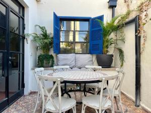 eine Terrasse mit Tisch und Stühlen und einem Fenster in der Unterkunft The TownHouse - Neve Zedek in Tel Aviv