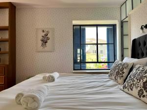 ein Schlafzimmer mit einem großen weißen Bett mit Handtüchern darauf in der Unterkunft The TownHouse - Neve Zedek in Tel Aviv