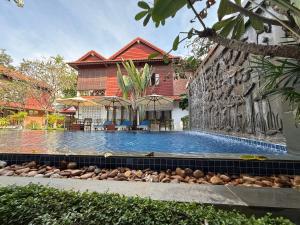 a swimming pool in front of a building at Banksy's Siem Reap in Phumĭ Réach Born (2)