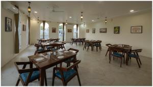 een restaurant met houten tafels en stoelen in een kamer bij Upvan Jawai - Unit of Dev Group in Bāli