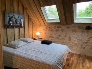 Rosnayles hébergements de la ferme des buttons的一间有两扇窗户的房间里有一张床的卧室