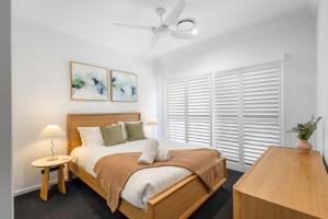 Luxury Pool Home Near Noosa & Coolum Sleeps 8 في Peregian Springs: غرفة نوم بها سرير ومروحة سقف +38 صورة