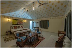 a living room with a bed and a table at Upvan Jawai - Unit of Dev Group in Bāli