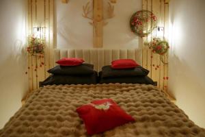 una camera da letto con un letto grande con cuscini rossi di Wiślański Renifer a Wisła
