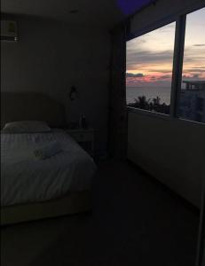 a bedroom with a bed and a large window at Karon Butterfly Phuket in Ban Karon