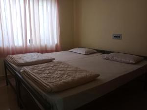 Dos camas individuales en una habitación con ventana. en Villa 9 degrees north, en Sultan Bathery