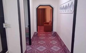 a hallway with a red tile floor and a red chair at Serenity House khlongnin in Phra Ae beach