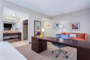 帕克斯堡汉普顿帕克市中心酒店（Hampton Inn and Suites Parkersburg Downtown）的酒店客房配有书桌和沙发。