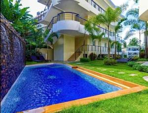 a swimming pool in front of a house at Karon Butterfly Phuket in Ban Karon