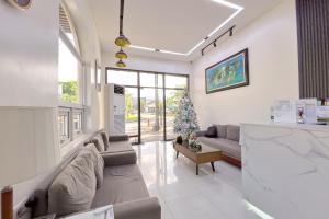 クラークにあるOlle Hotel Clark City powered by Cocotelのリビングルーム(ソファ、クリスマスツリー付)