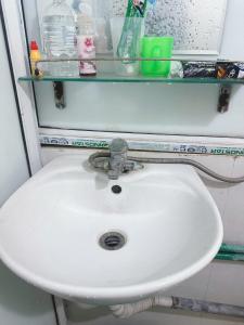 een witte wastafel met een glazen plank erboven bij Đồng Xanh 502NK in Hanoi