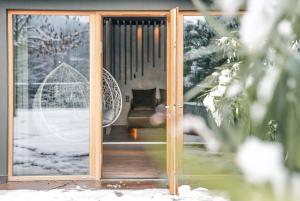 eine Glasschiebetür mit einer Couch dahinter in der Unterkunft Alpwellhotel Burggräfler in Tisens