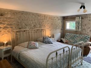 un dormitorio con una cama y un sofá en les hébergements de la ferme des buttons, en Rosnay