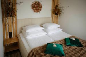a bedroom with a bed with white pillows and greens at Wiślański Renifer in Wisła
