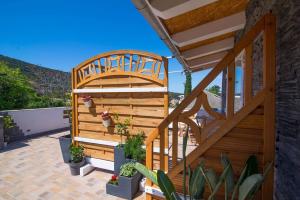 a wooden deck with potted plants on a patio at Andrej studio A2 in Veli Lošinj