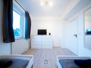 Habitación blanca con 2 camas y TV en Apartment im Zentrum von Ahrensburg, en Ahrensburg
