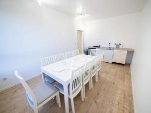 una mesa de comedor blanca con sillas blancas y una cocina en Apartment im Zentrum von Ahrensburg, en Ahrensburg