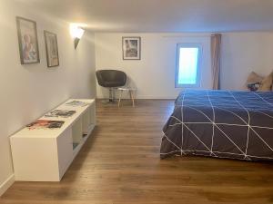 ein Schlafzimmer mit einem Bett, einem Schreibtisch und einem Stuhl in der Unterkunft Charmant Loft in Cluses