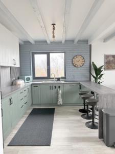 a kitchen with green cabinets and a table and a clock at SweetNest in Gurahonţ