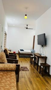 a living room with a couch and a tv at Green Villa Chirackal Gardens in Trichūr