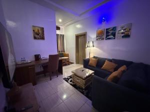 a blue living room with a couch and a desk at Akure Airport Hotel in Oba Ile