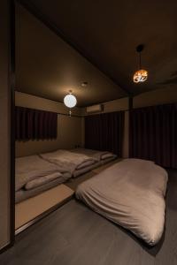 two beds in a dark room with two lamps at おやど紀伊国屋えびす町 in Nagasaki