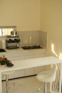 Una cocina blanca con una encimera y una mesa blancas. en Villa Pangkung, en Uluwatu