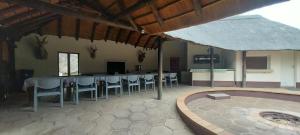 Lama Lama Game Reserve في Mount Hope: غرفة طعام كبيرة مع طاولة وكراسي