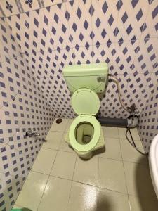 een badkamer met een groen toilet in een stal bij P Square Resto Cafe n Stay in Darjeeling