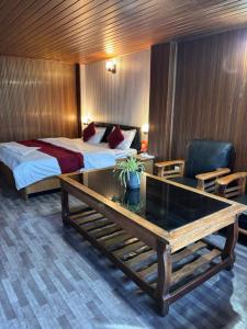 een hotelkamer met een bed en een bureau met een tafel bij P Square Resto Cafe n Stay in Darjeeling