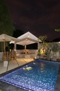 Una piscina en un patio trasero por la noche. en Villa Pangkung, en Uluwatu