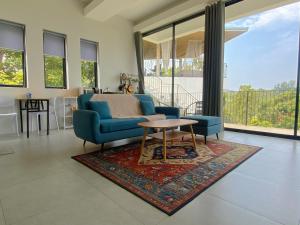 a living room with a blue couch and a table at Kanchaya Residence Apartment in Ko Ma