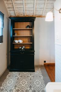 a black cabinet in a room with a rug at L'Al-Golette by Curtis in Mellet